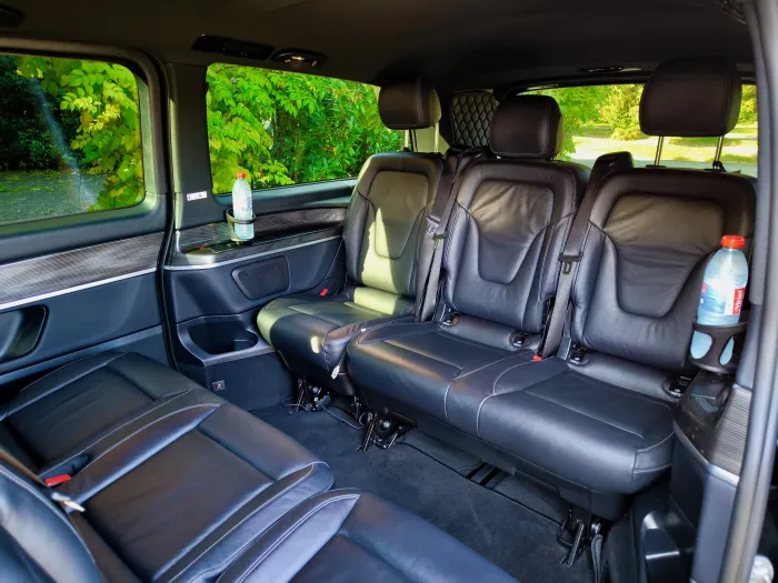 Banquettes en cuir noir face à face à l’arrière du van Mercedes